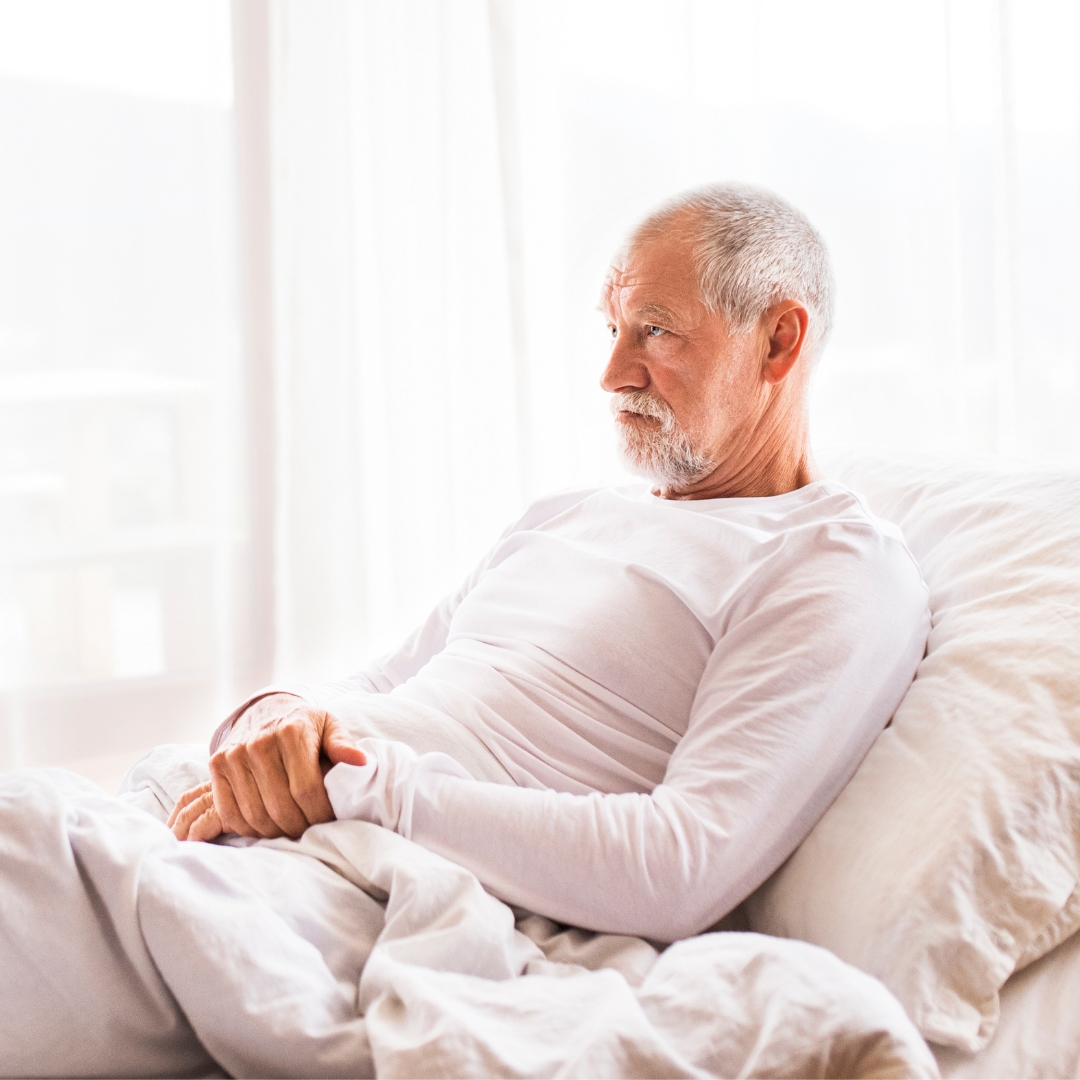 Older man laying in his adjustable bed