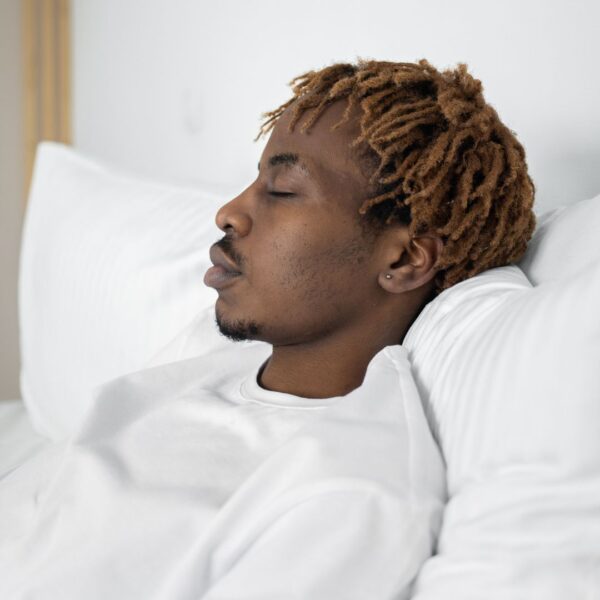 man sleeping on many pillows