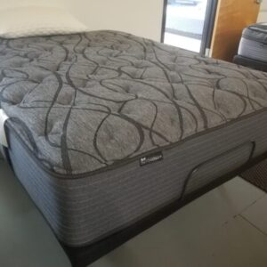 Showroom scene featuring a Dutchcraft mattress on a low frame with a pillow nearby.