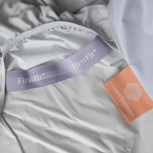 Grey sheet interior showing a purple FirstFit band next to an orange Comfort Innovation tag.