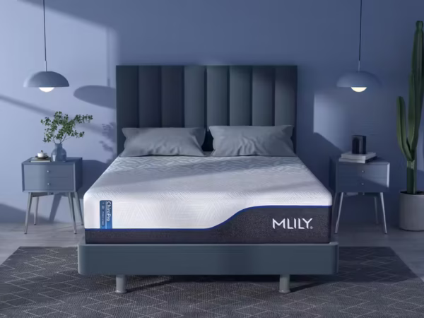 Blue-hued bedroom featuring an MLILY mattress with white top on an upholstered bed frame.